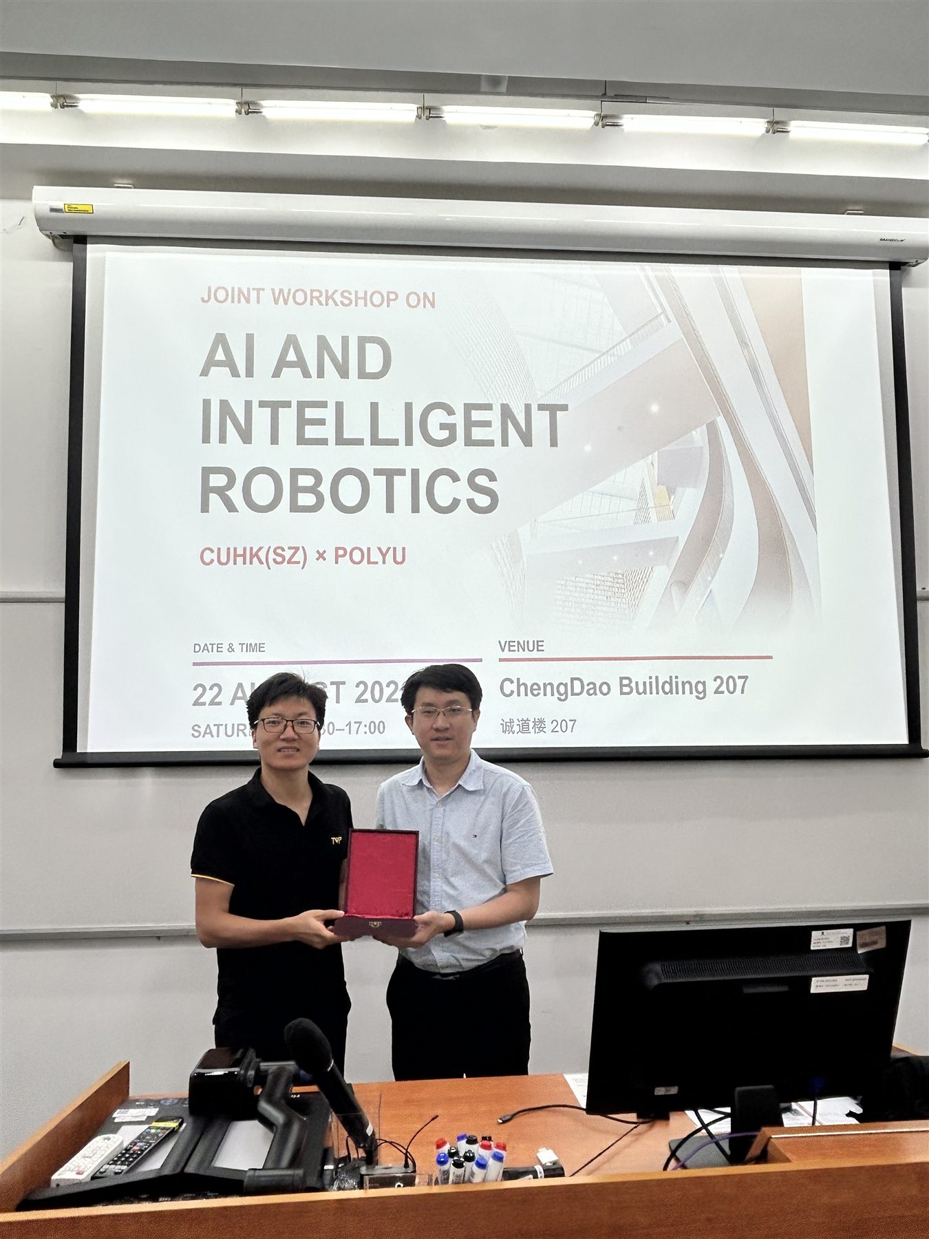 Representatives of PolyU and CUHK-Shenzhen exchange a commemorative token at the workshop
