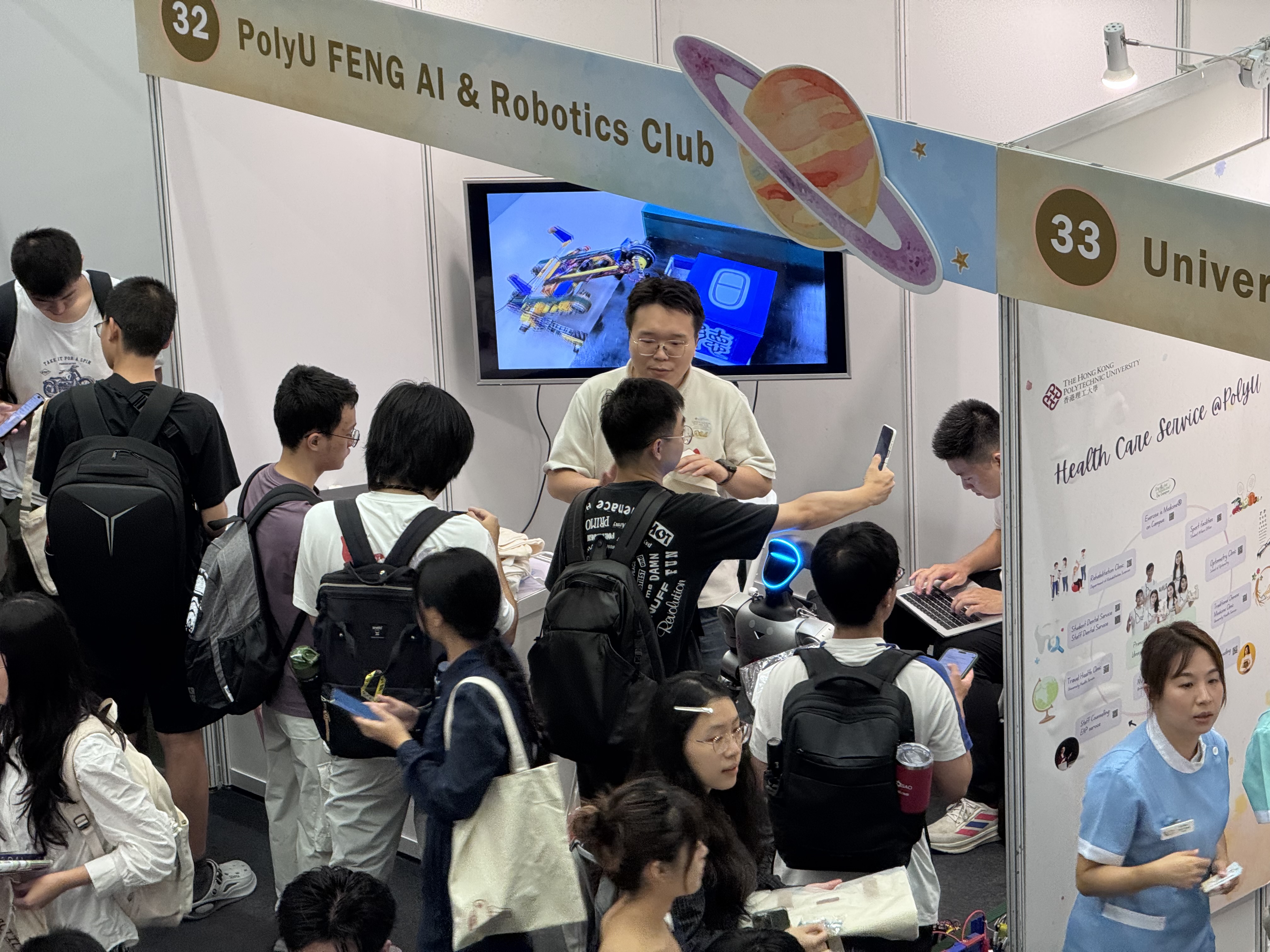 Students learning about projects at the PolyU FENG AI and Robotics Club booth