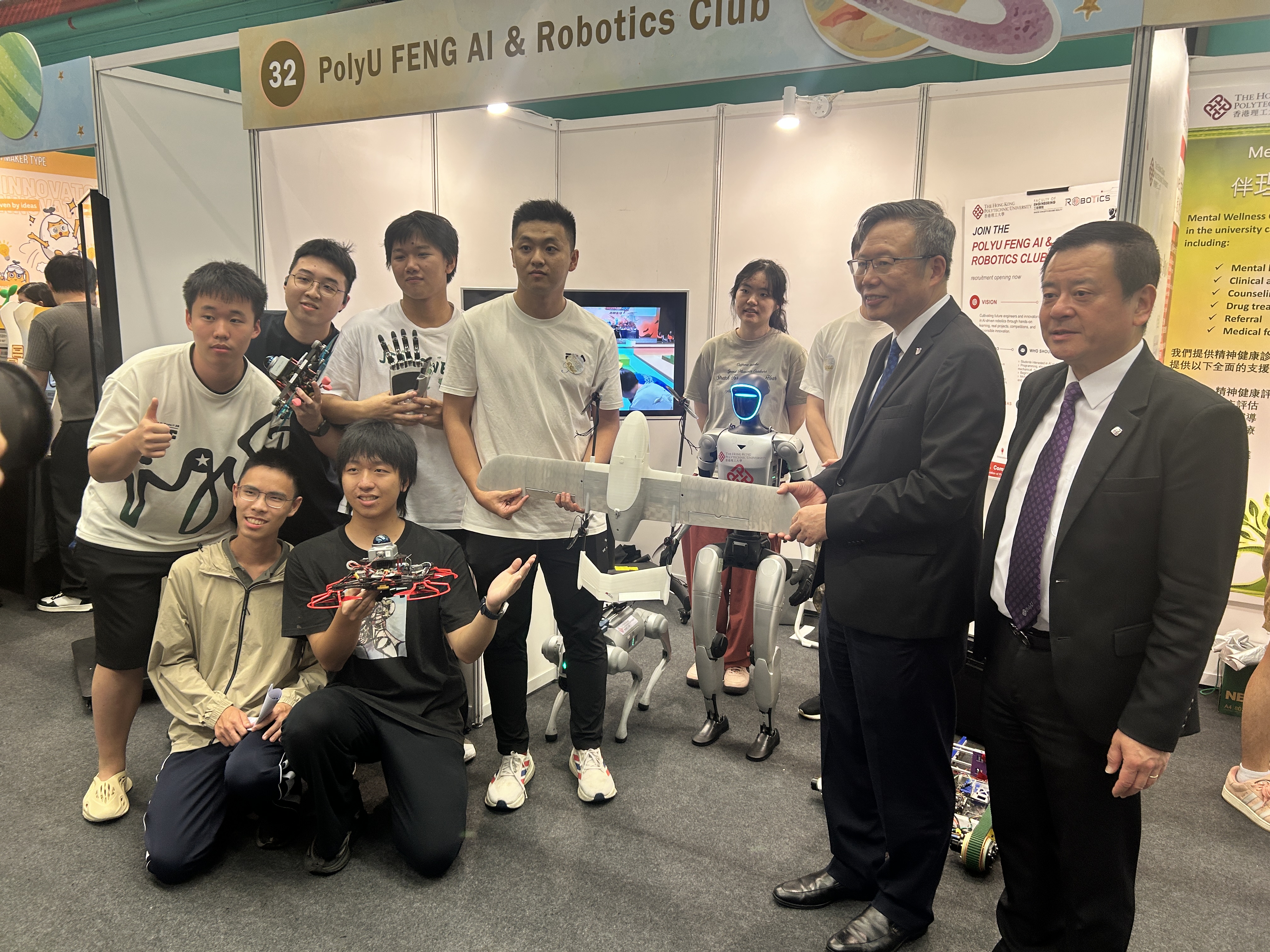 The President of PolyU with students and robotic exhibits at the club booth