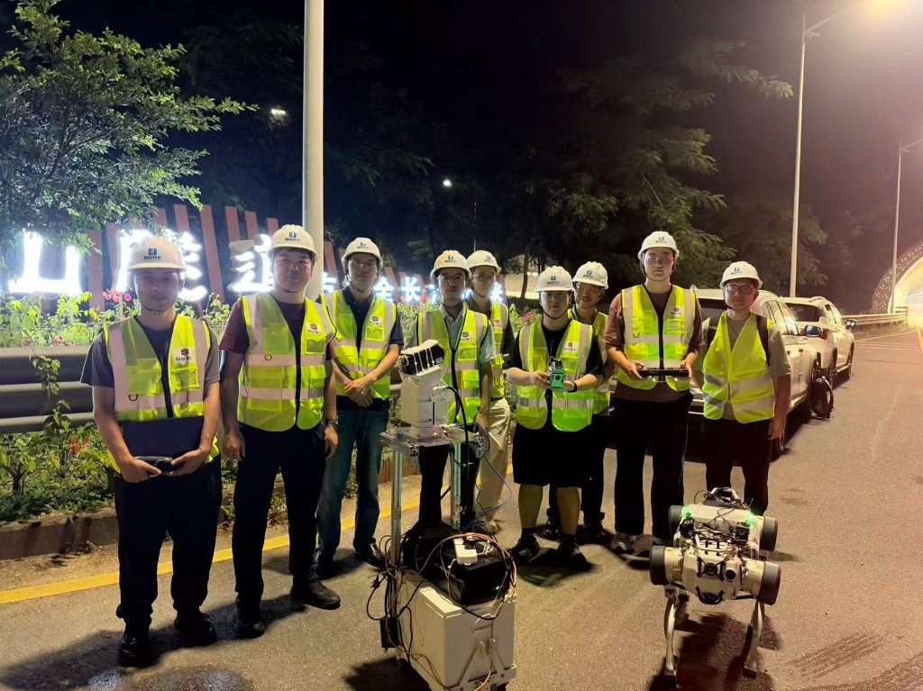 Team members in safety gear with the robotic platforms beside the tunnel road
